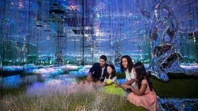 Family exploring the immersive light installations inside AYA Universe Dubai at Wafi City