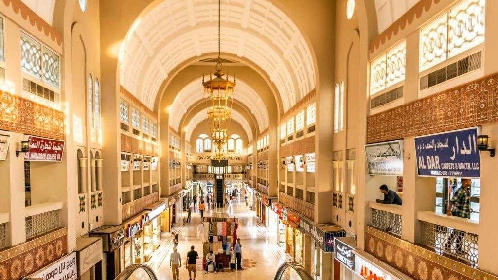 Interior of Blue Souk Sharjah featuring traditional Arabian architecture, shops, and arched walkways.