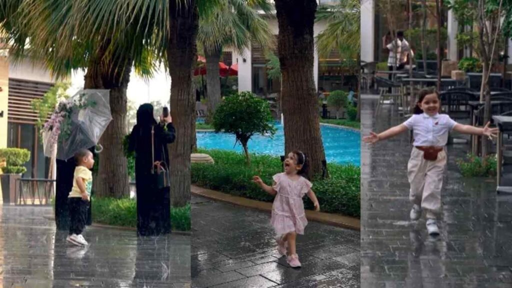 Children enjoying the artificial rain show at Zawaya Walk in Sharjah, with families walking beside the palm lined waterway.