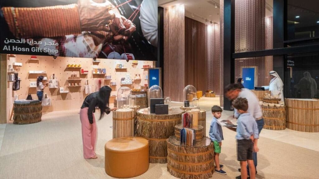 Visitors explore the Cultural Foundation and House of Artisans in Abu Dhabi, featuring heritage craft displays, gift shop exhibits, and interactive cultural experiences in a modern indoor space.