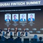 Panel discussion at the Dubai FinTech Summit with four industry leaders on stage discussing sustainable economic growth. A large screen behind them displays the session title, speaker profiles, and Dubai FinTech Summit branding, with attendees seated in the audience.