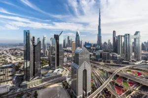 A busy highway interchange is seen in the foreground with the Burj Khalifa in the distance.