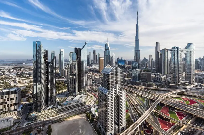 A busy highway interchange is seen in the foreground with the Burj Khalifa in the distance.
