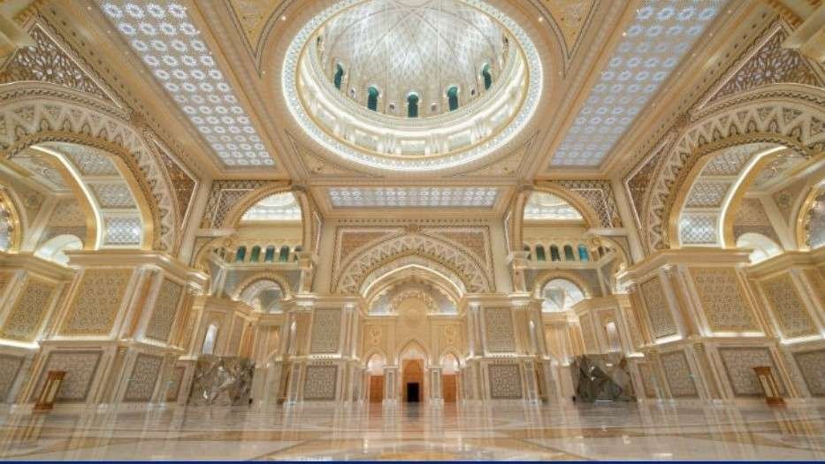 The Great Hall inside Qasr Al Watan, featuring intricate Arabic architecture, a vast marble floor, ornate arches, and the palace's famous domed ceiling.